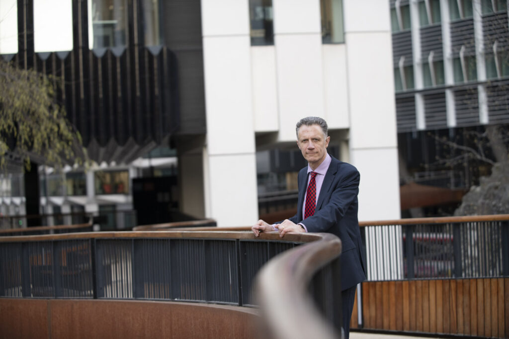 A Professional Business Mentor in London surrounded by tall buildings a on a bridge