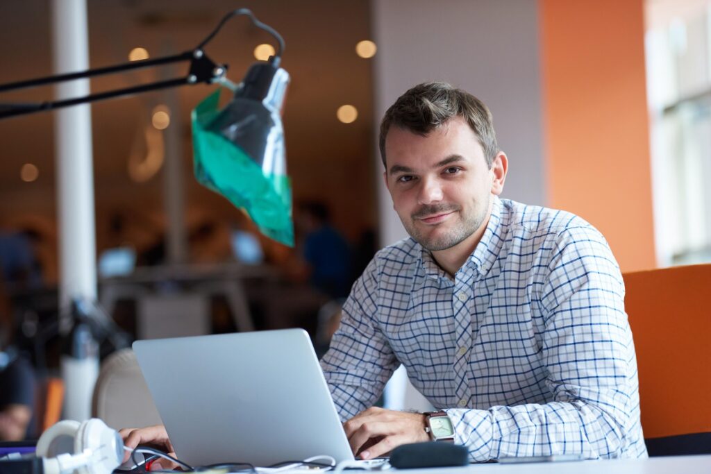 Image of man in front of his computer looking at the camera, representing 
